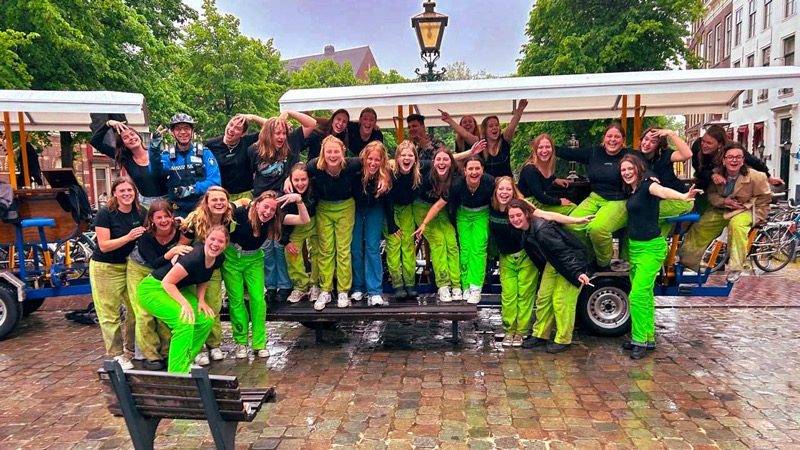 Group celebrating in front of beer bike