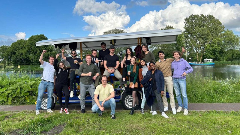 Large group posing with their beer bike